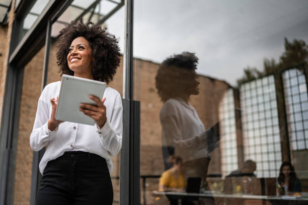 Businesswoman looking away and using digital tablet in an office
